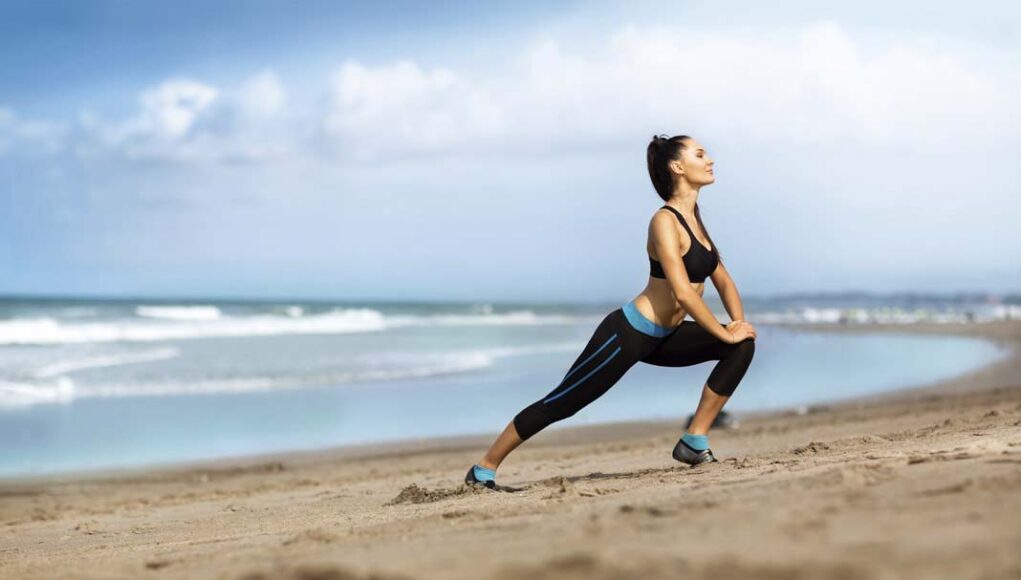 Attractive woman stretching on the beach